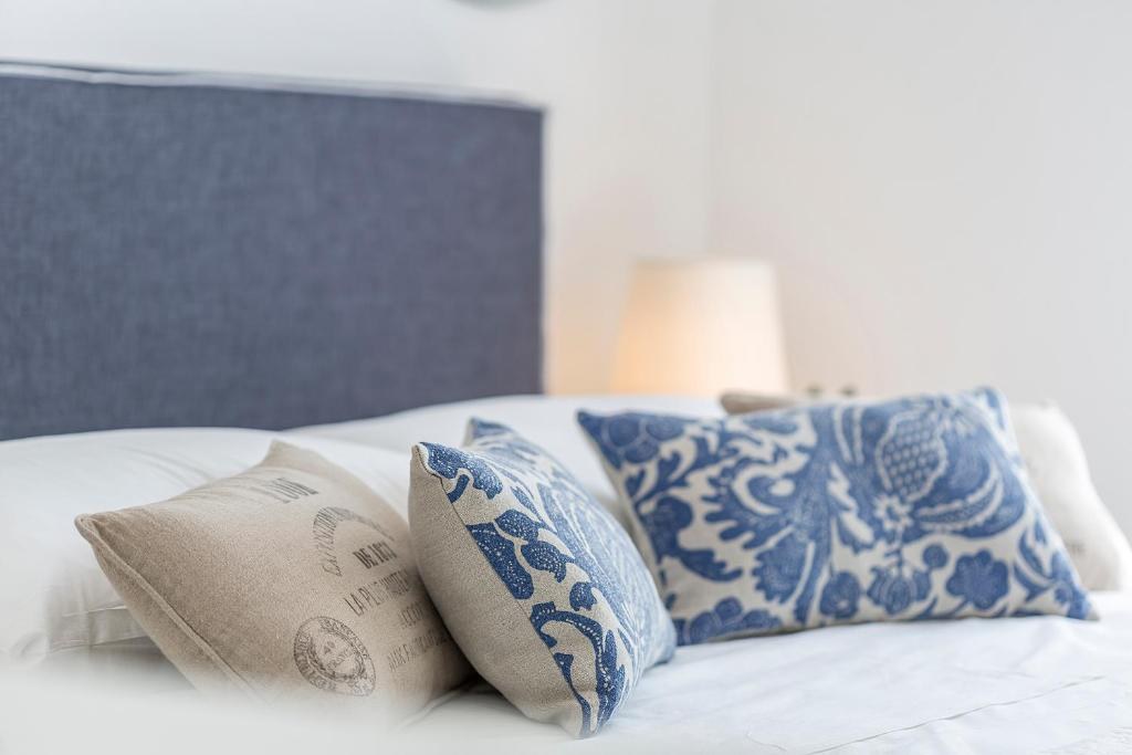 Bed with blue and white pillows at Piano Nobile Rooms in Split