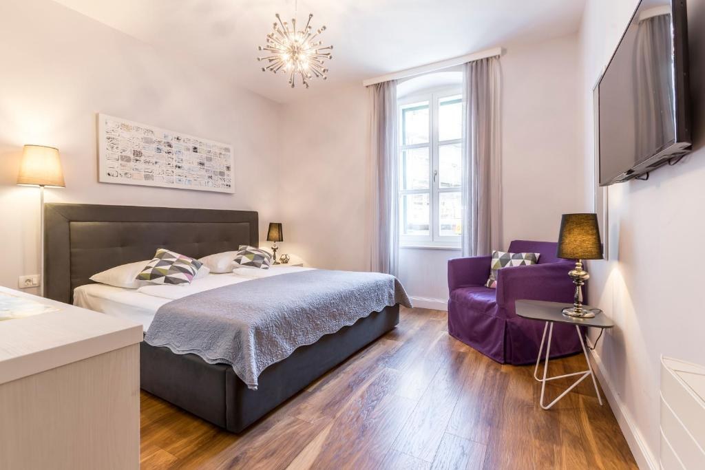 Bedroom with a purple chair at Piano Nobile Rooms in Split